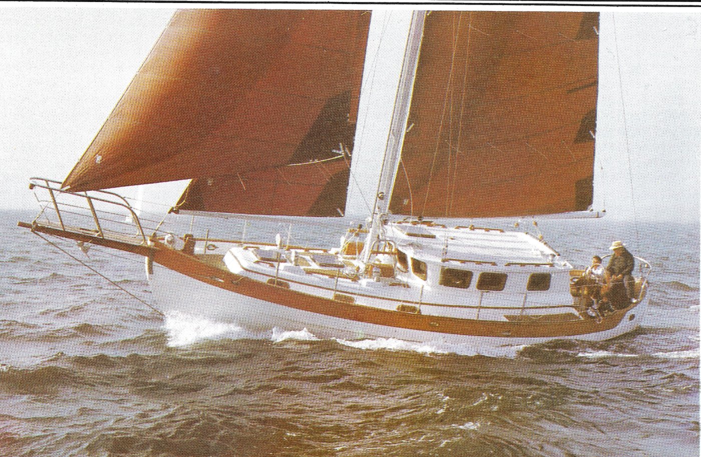 Hans Christian 39 Pilot House heeled over under tan bark sails.